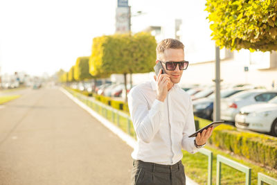 Young man using mobile phone while standing on bus