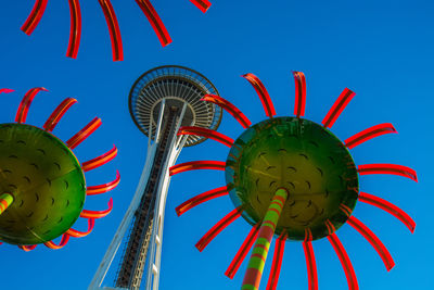 Low angle view of amusement park against blue sky