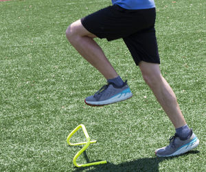 Low section of man skateboarding on field