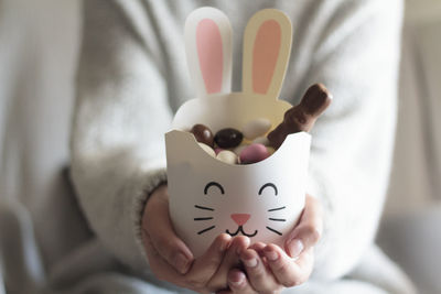 Woman hands holding rabbit box with easter candies inside