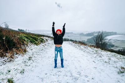 Rear view of man standing on snow field