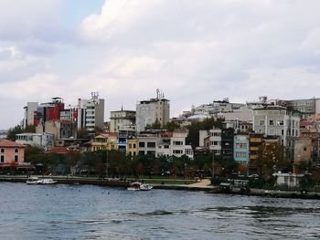 Sea by city against sky