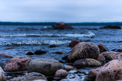 Close-up of pebbles on beach against sky