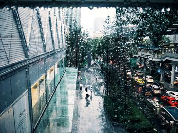 Wet street amidst buildings in city during rainy season