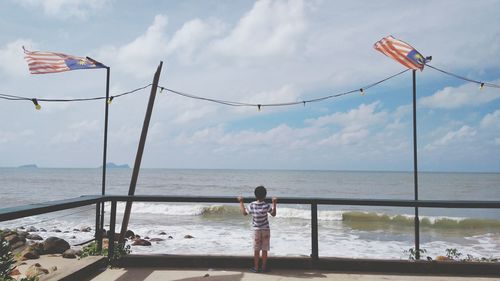 Woman standing on beach against sky