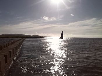 Silhouette of woman in sea against sky