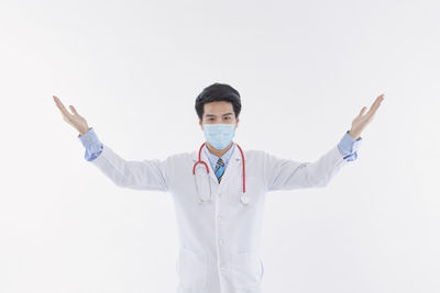 Portrait of young man standing against white background