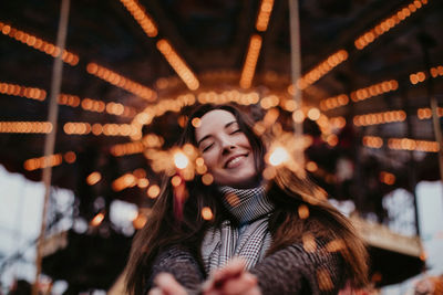 Happy woman with christmas sparklers on a background of golden holiday lights. new year holidays