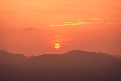 Scenic view of silhouette mountains against romantic sky at sunset