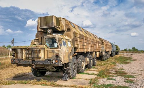 Abandoned truck on field against sky