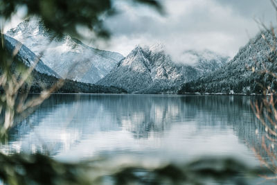 Scenic view of lake by mountains against sky