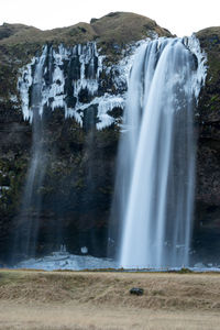 Scenic view of waterfall against sky