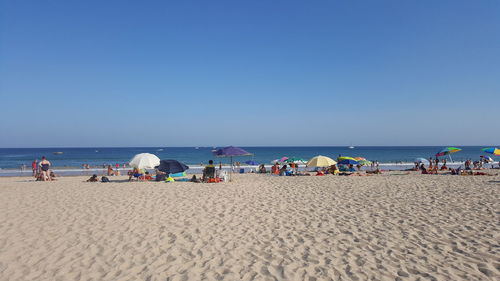 Panoramic view of beach against clear blue sky