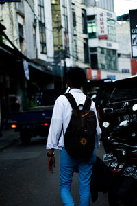 Rear view of men walking on city street