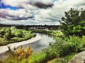 Scenic view of river by trees against sky