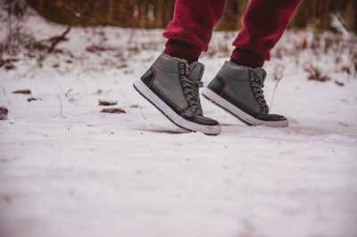 Low section of person standing on snow