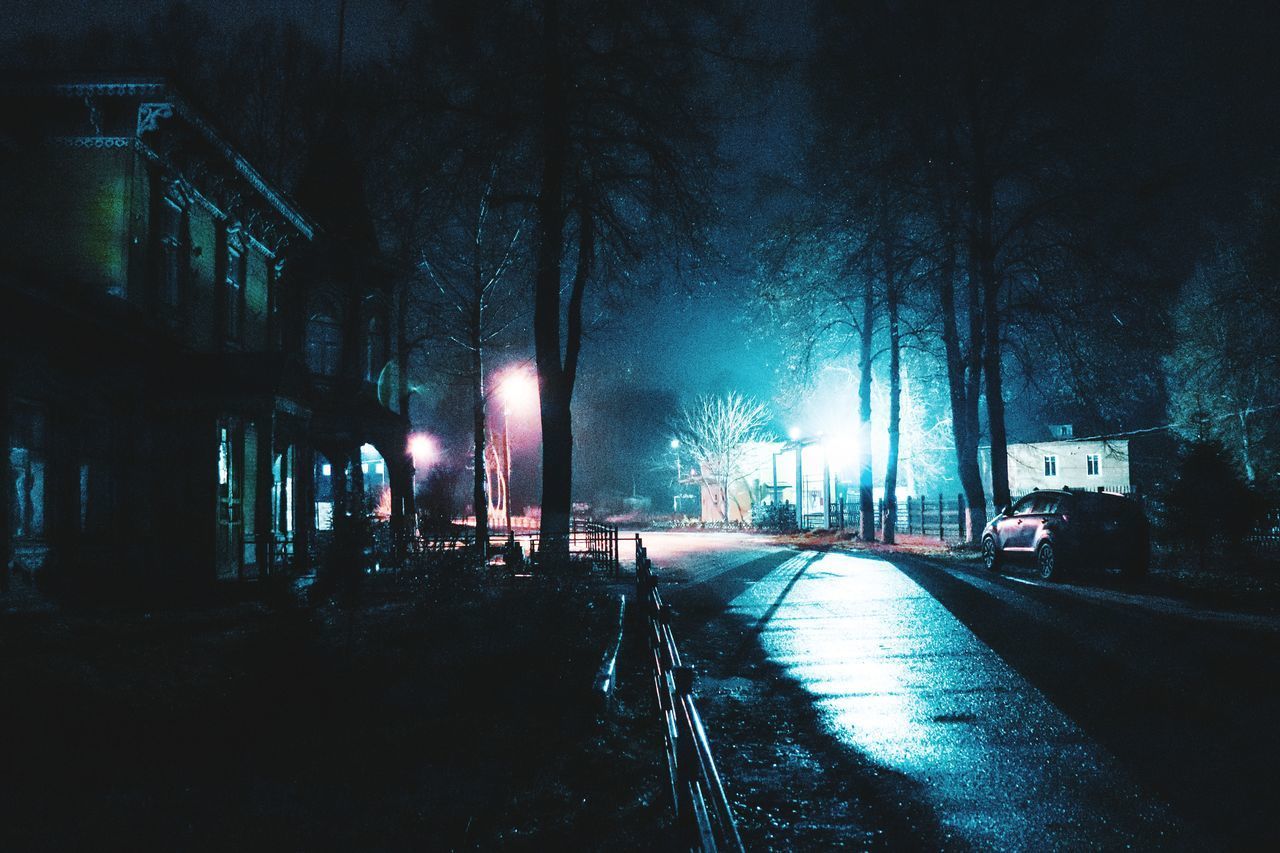 ILLUMINATED STREET IN CITY AT NIGHT