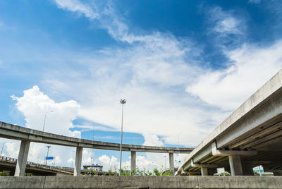 Low angle view of bridge and buildings against sky