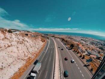 Aerial view of highway by sea against sky