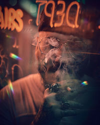 Close-up of man smoking at night