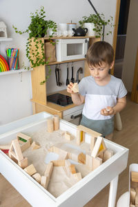 Portrait of cute boy sitting on table at home