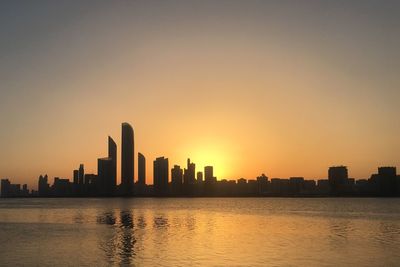 Silhouette buildings against sky during sunset