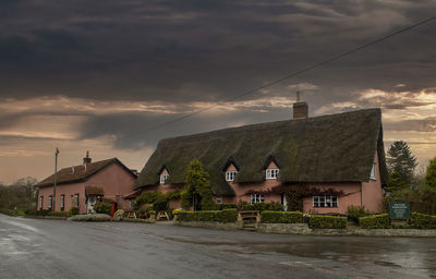 Dark clouds over the four horseshoes pub in thornham magna, suffolk, uk