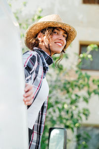 Smiling young woman looking away while standing outdoors