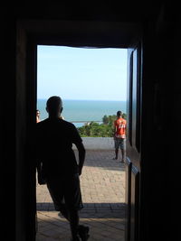 Men standing by window in sea