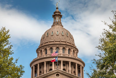 Texas state capitol building in austin, with the flags of texas and the usa