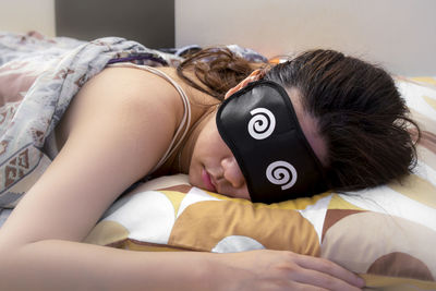 Close-up of baby lying on bed at home