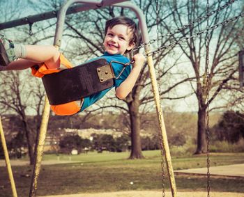 Portrait of boy on swing in playground