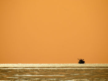 Scenic view of sea against orange sky