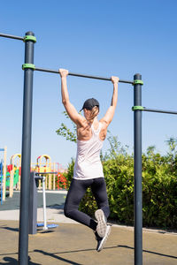 Rear view of young woman exercising in park