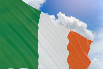 Low angle view of irish flag against sky