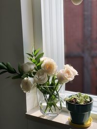 Close-up of white roses in vase on table