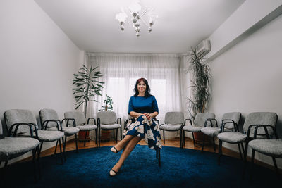 Portrait of young woman sitting on sofa at therapy room