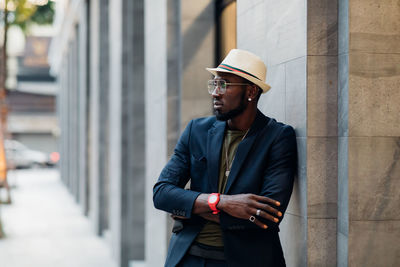 Man leaning on wall in city