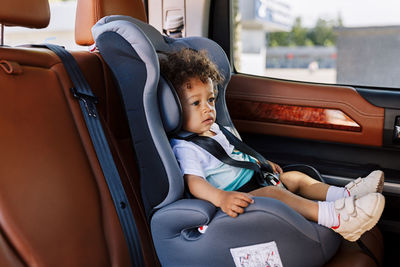 Boy sitting on seat in bus