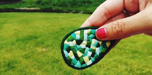 Cropped image of woman holding embroidery at field