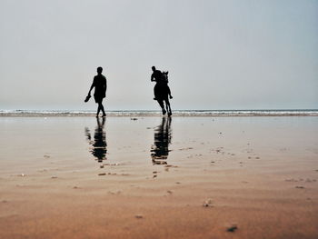 People on beach against sky