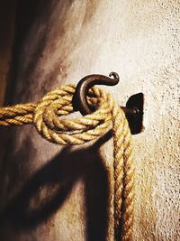 Close-up low angle view of rope tied on hook in wall