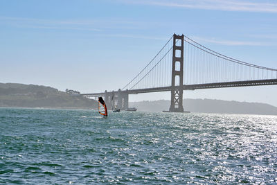 Suspension bridge over sea against sky