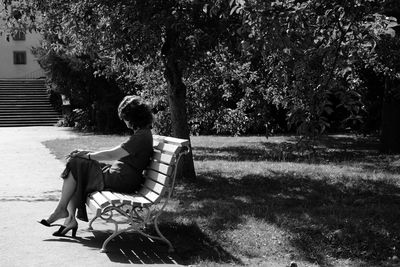 Rear view of girl sitting on grass in park