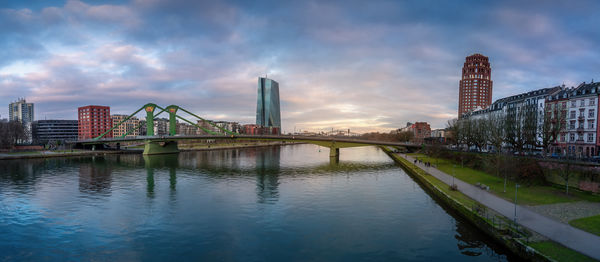 Bridge over river against cloudy sky