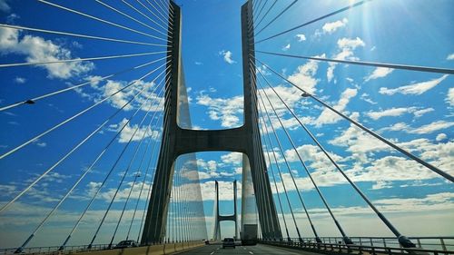 Low angle view of suspension bridge against blue sky