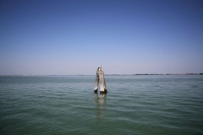 Man swimming in sea against clear sky