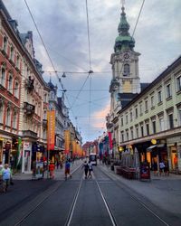 People walking on road along buildings