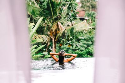 Woman on tree by water