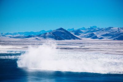 Scenic view of snowcapped mountains against clear blue sky